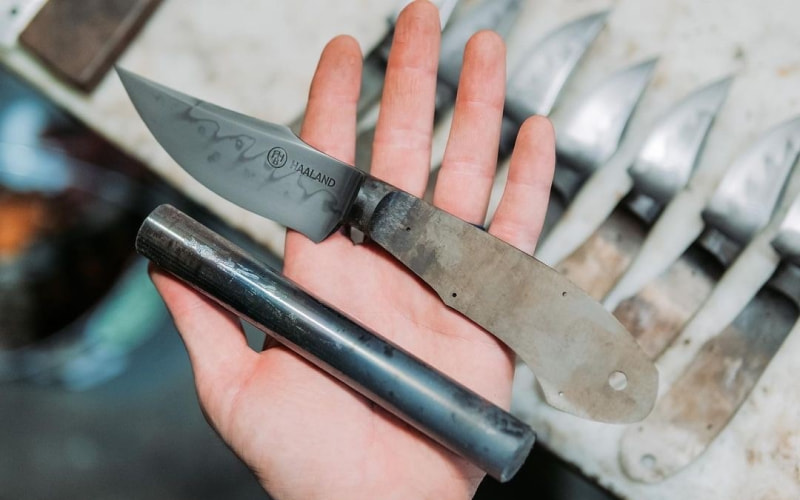 Freshly forged blade and steel rod in smiths hand