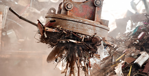 Powerful magnet at a scrap yard holding up scrap metal